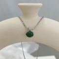 Detail van ketting met groene aventurijn hanger op een decoratieve keramische vaas - Zilveren Donkergroene Steen Ketting (CDP986)
