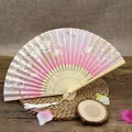 Detail showing Japanese folding fan with pink cherry blossoms and white silk tassel - Pink White Cherry Blossom
