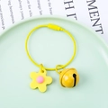 Close-up of yellow flower charm and bell pendant on a steel wire loop keychain - Wire Ring + Soft Flower + 22mm Bell / Yellow