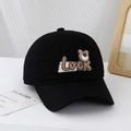 Close-up of black cotton baseball cap featuring luck bear patch and embroidered air holes - 54cm (3-8 Years) / Black