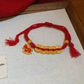 Gros plan du bracelet en corde rouge tressée avec pendentif cheval et pièces dorées - 9# Bracelet-Or-Rouge-Pièces (Cheval à Bascule Succès)