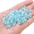 Polished blue glass jelly beads held in hand for handmade jewelry DIY projects - Light Blue approx 50pcs/pack