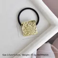 Macro detail of 3.5cm gold square hair tie with irregular fluid texture on black elastic - Gold Embossed Square