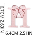 Pink embroidered letter H patch with a bow design, showing dimensions 6.7cm x 6.4cm - Bow Alphabet Letter H