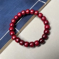 Bracelet de perles en bois rouge foncé posé sur un livre ancien traditionnel - Perles Classiques en Bois de Santal de Sang / 8mm*22 Perles