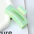 Macro shot of large light green pearlescent hair claw clip on a minimalist white tray - 8.5cm Rectangular / 2# Laser Iridescent Green