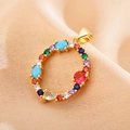 Detailed macro of golden letter O pendant with vibrant multi-colored zirconia stones - Letter O