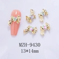 Detail of 13x14mm gold metal bow nail art charm with a heart-shaped crystal on pink nail - Gold Bowknot Pink Green Heart(9430)