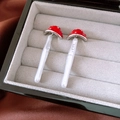 Vista detallada de pendientes de hongo rojo con bordes plateados en una caja de joyas - Estilo de Champiñón Rojo y Blanco (Pin de Plata)