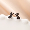 Detailed close-up of black cat stud earrings with heart cutout on a ceramic tray - Cat with Heart (787) / Black
