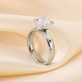 Side view of a silver six-claw solitaire ring on champagne silk fabric background - Women's Six-Claw Zirconia Style (KR43434-K)
