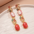 Detail von Vintage-Cameo-Ohrringen mit Blumenemaille und funkelnden Kristallen - Cameo Porträt Blume Ohrringe