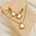 Elegant gold trapezoid necklace and earrings jewelry set on textured stone backdrop - White Shell Necklace + Earrings Set