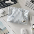 Pochette trucchi a righe blu con ricamo a fiocco su una scrivania con computer portatile - Striscia Blu Fiocco Blu