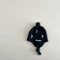 Detail of baby knitted earflap hat featuring white moon jacquard and soft pompom - 1-2 years old / Navy Moon