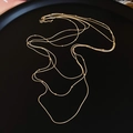 Élégant collier multi-rangs à pampilles dorées présenté sur un plateau noir mat - Doré