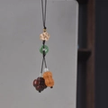 Detailed view of handmade wood carved persimmon and peanut keychain with jade ring accents - Good Things Happen Phone Chain Type 1