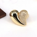 Vue macro d'une bague coeur plaquée or 18k avec un côté serti de cristaux brillants - Design de cœur pavé 3D