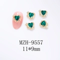 Bijou d'ongle cœur vert avec bordure dorée 11x9mm présenté sur un faux ongle rose - Base Dorée - Zircon Vert Foncé (9557)