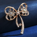 Elegant gold bow brooch featuring sparkling rhinestones on a premium blue velvet background - Gold Bowknot
