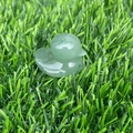 Macro shot of a small green aventurine gemstone duck carving on green grass - Green Aventurine