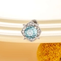 Silver flower stud earring with a round blue gemstone and diamond-like halo - Sea Blue (Single)