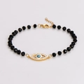 Detail van zwarte kralenarmband met gouden evil eye bedeltje en karabijnsluiting - Armband