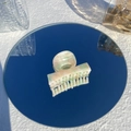 Close-up of marble pattern hair claw clip on mirror surface with natural sunlight - Peach Ice