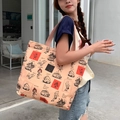 Detail of salmon pink canvas tote bag featuring Toy Story character prints on model - Vintage Diary