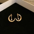 Close-up of golden moon earrings with zircons in a black velvet jewelry box - Gold