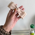 Elegant champagne satin bow hair clip with a smooth ribbon texture and spring clip base - Off-white