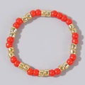 Detailed close-up of vibrant orange beaded bracelet with gold metallic accents - Orange Red and Gold
