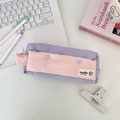 Close-up of purple and pink fabric pencil case with blue heart buttons on desk - Light Purple