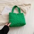 Vibrant green quilted tote bag featuring heart pattern texture and gold snap closure - Green