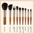 Set de 9 brochas de maquillaje con mangos de madera y férulas plateadas en fondo beige - Color Madera Natural Juego de 9 Piezas + Bolsa OPP