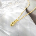 Dettaglio del ciondolo a goccia placcato oro 18K con catena a sfere su tessuto bianco - Solo Ciondolo (Senza Catena) / Lettera I