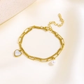 Detail showing gold double-layer chain with heart shell pendant and pearl on silk fabric - Heart White Shell Pearl Style