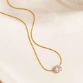 Dettaglio della collana dorata con montatura a sei griffe e zircone rotondo scintillante - Catena a Serpente Dorata