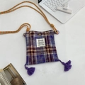 Macro shot of purple plaid fabric texture with long tassel and woven strap detail - Purple
