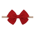 Macro detail of red bow baby headband showing soft textured fabric and elastic nylon band - True Red