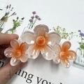 Elegant hair claw clip with three resin plumeria flowers in orange gradient finish - Orange