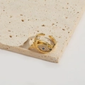 Golden Evil Eye open ring with blue gemstone and clear crystals on a beige stone base - Evil Eye Style