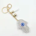 Hamsa Hand und Evil Eye Schlüsselanhänger mit Strasssteinen und weißer Quasten - Weiß