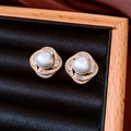 Vue macro de boucles d'oreilles perles style français avec zircon sur velours noir - Blanc