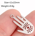 Hamsa-Hand-Anhänger aus Edelstahl mit Augen-Detail auf einer Fingerspitze - Hamsa Hand / Stahlfarben
