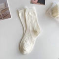 Close-up of white JK socks with delicate lace frill edges and floral knitted patterns - Lace Trim