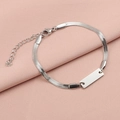 Macro shot of silver stainless steel herringbone chain bracelet with blank ID plate - Steel / Steel