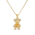 Macro detail of bear pendant with white and orange rhinestones on gold necklace - Yellow