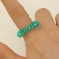 Detail eines blaugrünen Finger-Massage-Rings zur Druckentlastung an der Hand - Grün