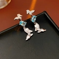 Detailed macro view of butterfly stud earrings with blue zircon stones on black surface - 12# Silver Blue Butterfly Earrings